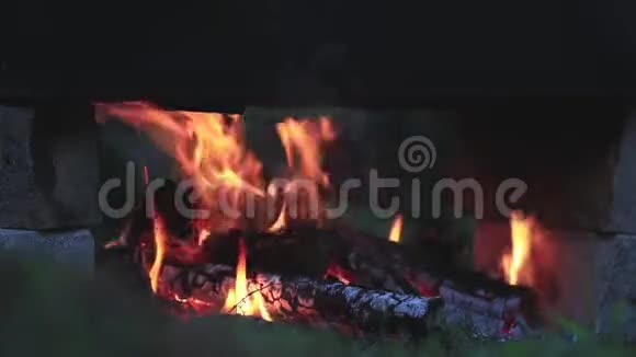 火里有烧焦的木头在黑暗中在明亮的火焰中燃烧木材近距离动态的场景色调的视频视频的预览图