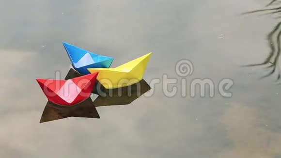 三只小彩纸船浮在水面上视频的预览图