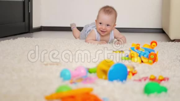 七个月大的小男孩在儿童房的地板上爬行孩子爬在地毯上后景视频的预览图