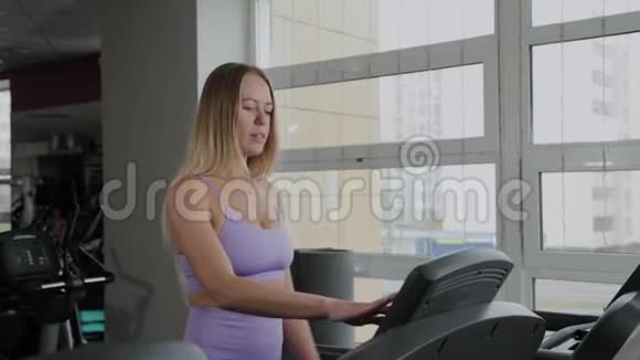有着美丽身材的运动女性正在跑步机上训练视频的预览图
