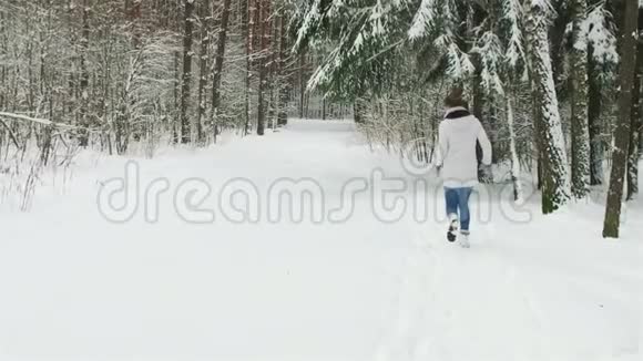 快乐的女孩在冬天的森林里奔跑视频的预览图