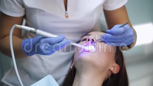 牙医诊所的妇女得到牙科治疗以填补牙齿的空洞牙科修复和材料视频的预览图