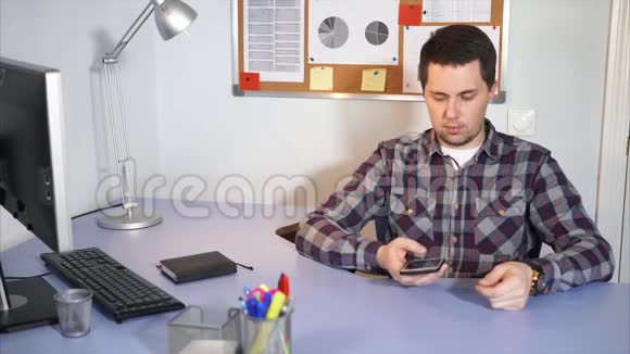 商人正在他的办公室里谈判智能手机那里有一台电脑视频的预览图
