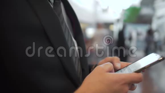 在精英智能手机上穿着商务服上网完成商务交易视频的预览图