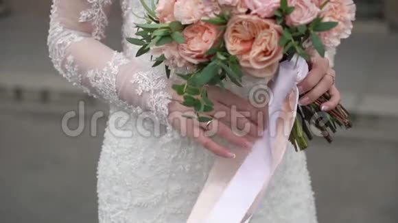 年轻的新娘穿着婚纱在城市里捧着花束白色豪华礼服视频的预览图