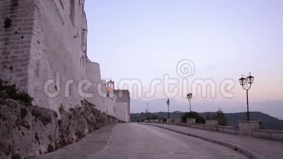 夏天日落时分在奥图尼白村的中世纪城墙上散步视频的预览图