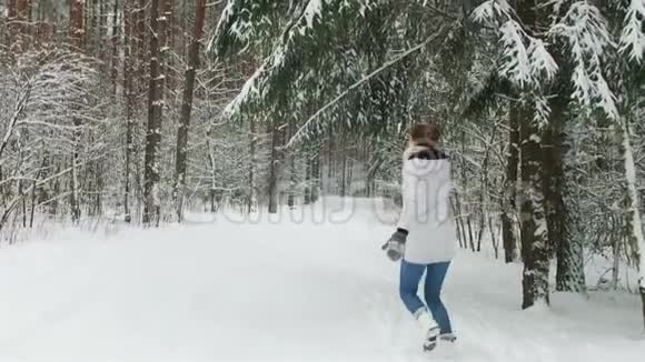 快乐的女孩在冬天的森林里奔跑视频的预览图