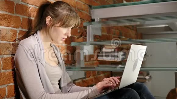 愤怒沮丧的女人在笔记本电脑上工作坐在楼梯上视频的预览图