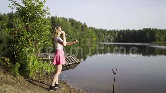 金发少女渔夫正在森林湖上钓鱼穿短裙的女人学会钓大鱼视频的预览图