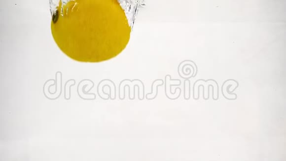 整个柠檬苹果和梨都掉进了一个透明的容器里里面有水带气泡的慢运动水果视频的预览图