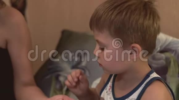 小男孩吃药片喝水生病的男孩服用药片和饮料视频的预览图