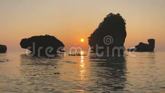 印度洋海岸浪漫日落在皮划艇上石灰石岩石从人们的头顶升起海面上泛起涟漪视频的预览图