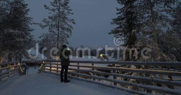 晚上在冬季度假村拍照的男人视频的预览图