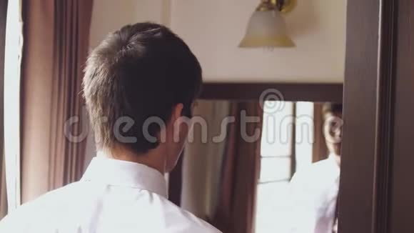 穿白衬衫的人站在镜子旁系领带慢动作3840x2160视频的预览图