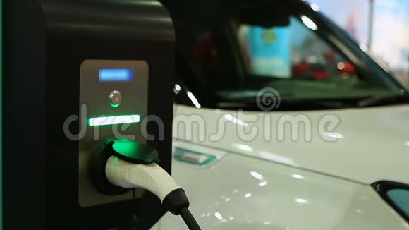 女测试电动车在车展车辆插入充电点视频的预览图