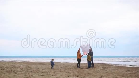 父母和孩子们在海岸上放飞纸灯笼视频的预览图