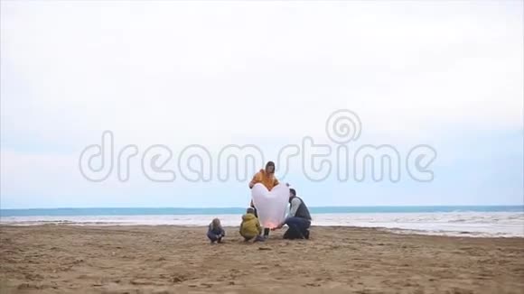 一个友好的家庭在海边点燃了一盏纸灯笼视频的预览图