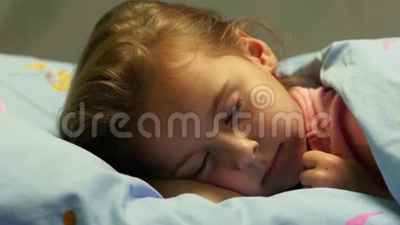 女孩醒来睁开眼睛专注地看着微笑着早上躺在床上的迷人女孩视频的预览图