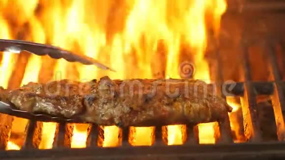 一块多汁的大牛排放在烤架上厨师用火焰把烤架上的牛肉羊肉或小牛肉视频的预览图