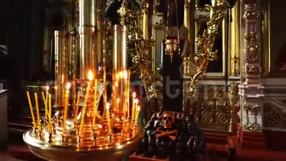 燃烧的蜡烛站在金色的教堂吊灯上背景上有许多神圣的图标视频的预览图