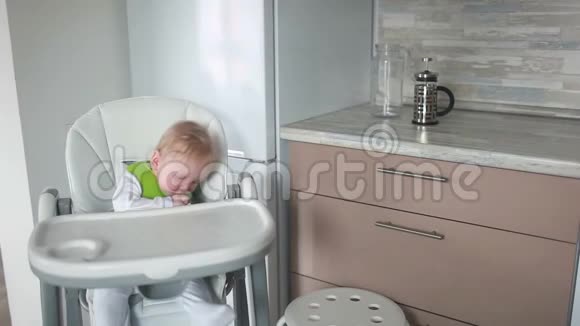 妈妈把婴儿奶酪放在一把高椅子上用一个鹳的器具视频的预览图