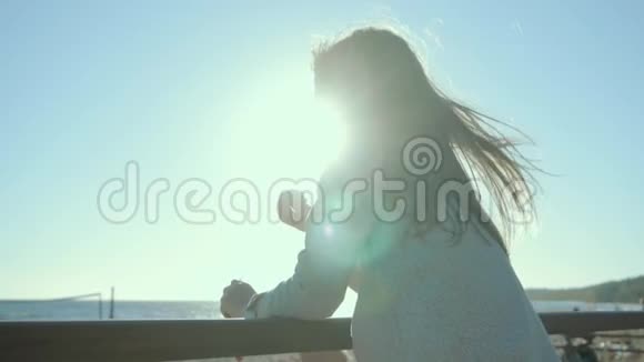 美丽的女孩站着斜靠在索洛莫海岸的扶手上视频的预览图
