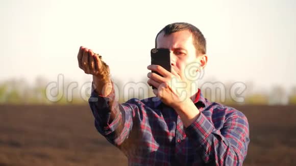 农民取一个黑色肥沃土壤的样本农民的一小撮肥沃的土壤矗立在耕地上土壤视频的预览图