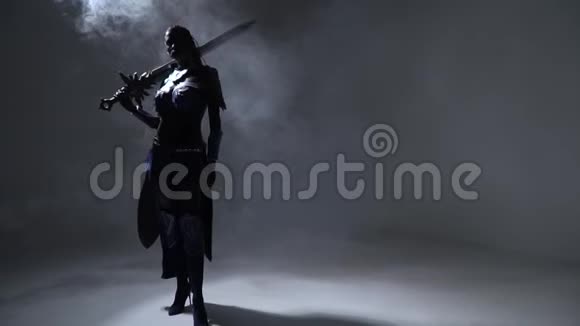 一个黑暗的精灵女人手持史诗般的剑在黑暗中烟雾缭绕视频的预览图