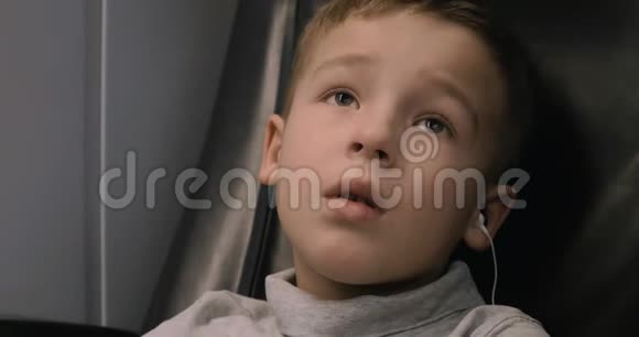 男孩在火车上看电视他用耳机听音频视频的预览图