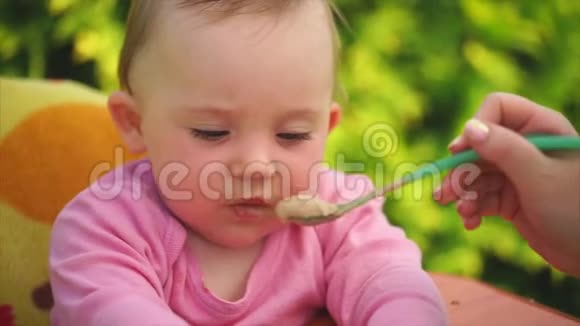 一个可爱有趣的孩子用勺子喂粥的画像视频的预览图