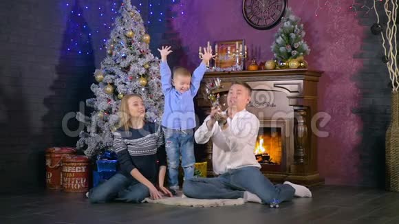 家人在圣诞壁炉附近扔纸屑慢动作视频的预览图