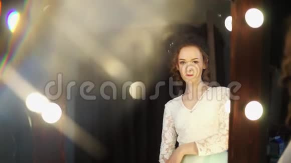 模特在新娘的形象通过一个美丽的镜子看相机视频的预览图