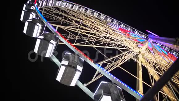 巨大的摩天轮与照明客车快速旋转游乐视频的预览图