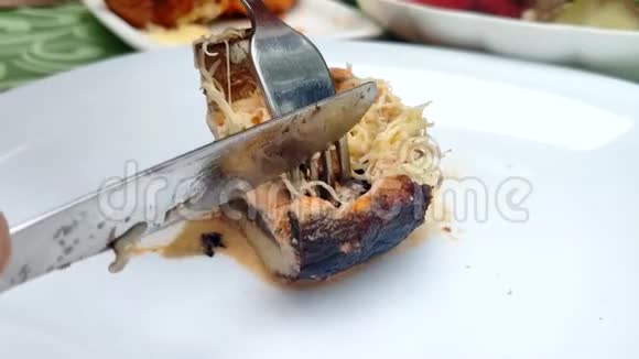 有人用叉子和刀切了一块烤蘑菇视频的预览图