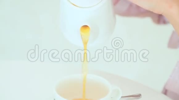 女人把茶倒进杯子里视频的预览图