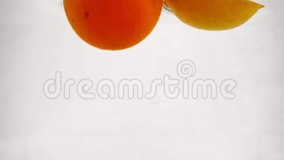 一整个葡萄柚橘子和柠檬掉进水里有气泡柑橘类水果慢动作视频视频的预览图