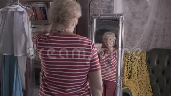 漂亮的老太太在镜子前打扮得漂漂亮亮的视频的预览图