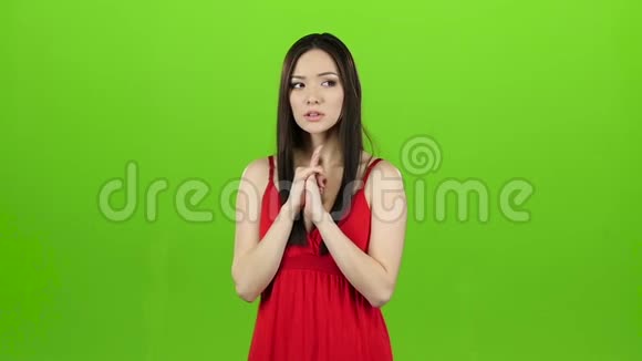 女孩是亚洲人希望赢并交叉她的手指绿色屏幕慢动作视频的预览图