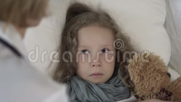 女医生在家里和一个躺在床上哭泣的女孩谈话医疗保健视频的预览图