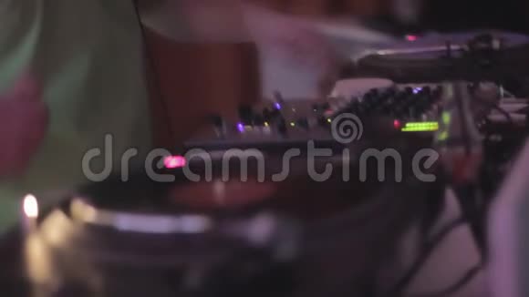 音响设备男DJ在搅拌机上按按钮在俱乐部播放乙烯基唱片视频的预览图