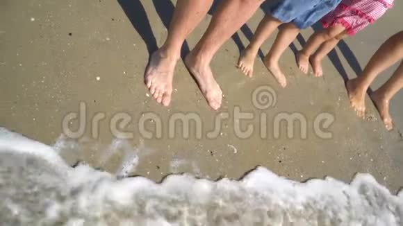 暑假假期概念幸福家庭父亲母亲达特儿子站在沙滩上的水里海水视频的预览图