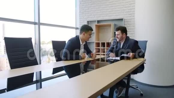 两个商人在办公室的商务会议上视频的预览图