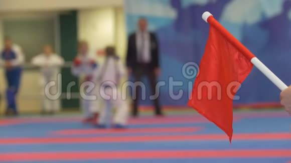 在空手道锦标赛的少年女孩面前挥舞红旗视频的预览图