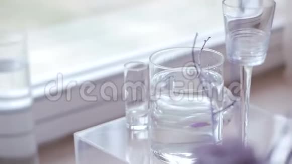 透明桌子背景上花瓶里的美丽花朵视频的预览图