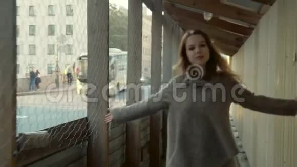 在秋天交通拥挤的城市街道上一个开朗的女孩走在一个木票上视频的预览图