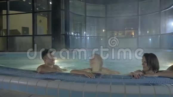 两个男人和两个女孩在桑拿后在游泳池里游泳视频的预览图