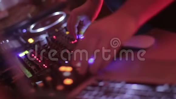 专业DJ在混合控制台制作音乐并享受他的工作视频的预览图