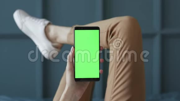 家中卧室中年轻女性手机绿色屏幕的色度键视频的预览图