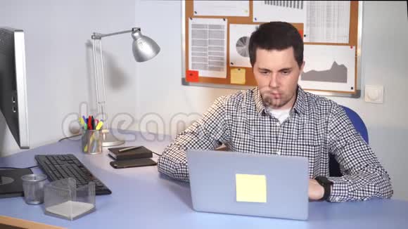 IT专家高兴地看着笔记本电脑显示器他喜欢在办公室工作视频的预览图