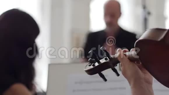 加速动作小提琴手在背景指挥的音乐台前演奏小提琴视频的预览图